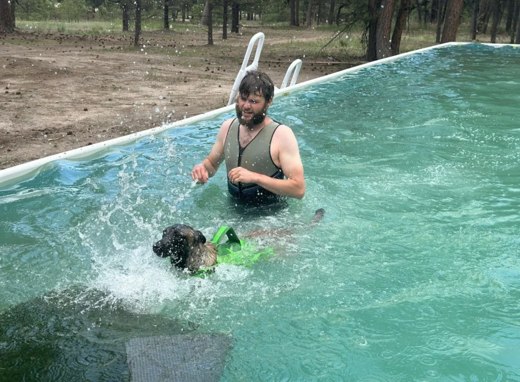 Caregiver in the pool with a dog during supervised enrichment.