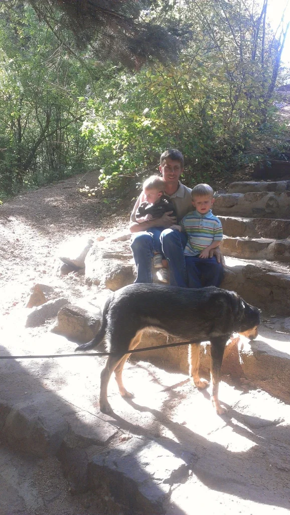 A member of the Pinnacle K9 family spending time with a dog outdoors.