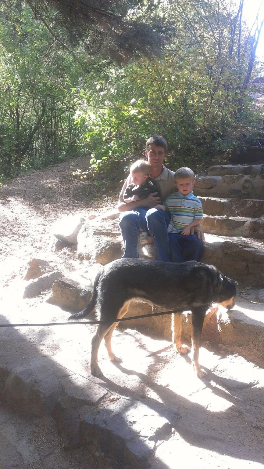 A member of the Pinnacle K9 family spending time with a dog outdoors.